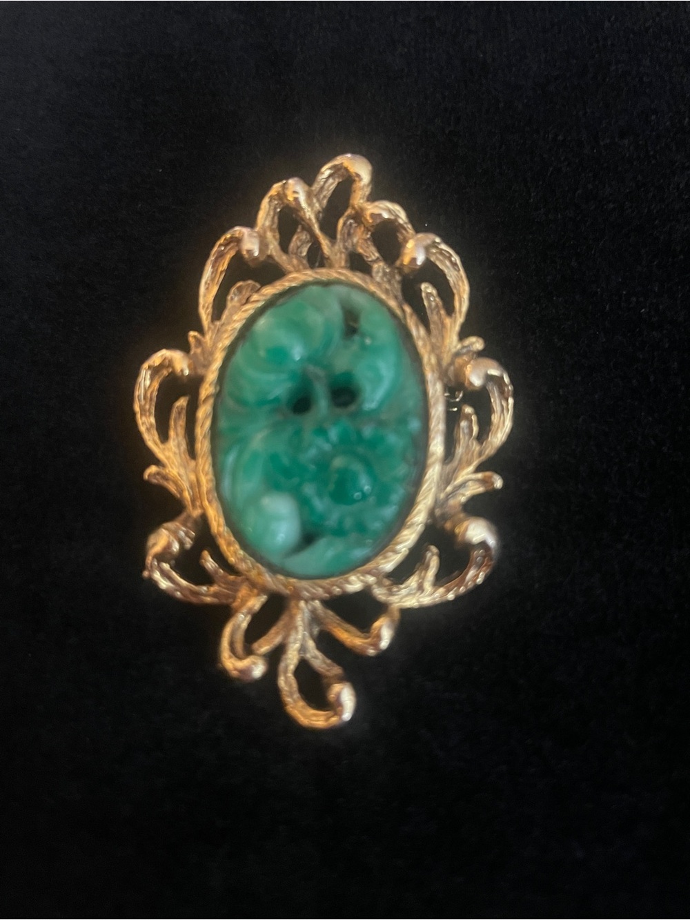 Vintage gold-tone filigree brooch features an ornate scroll and leaf border!